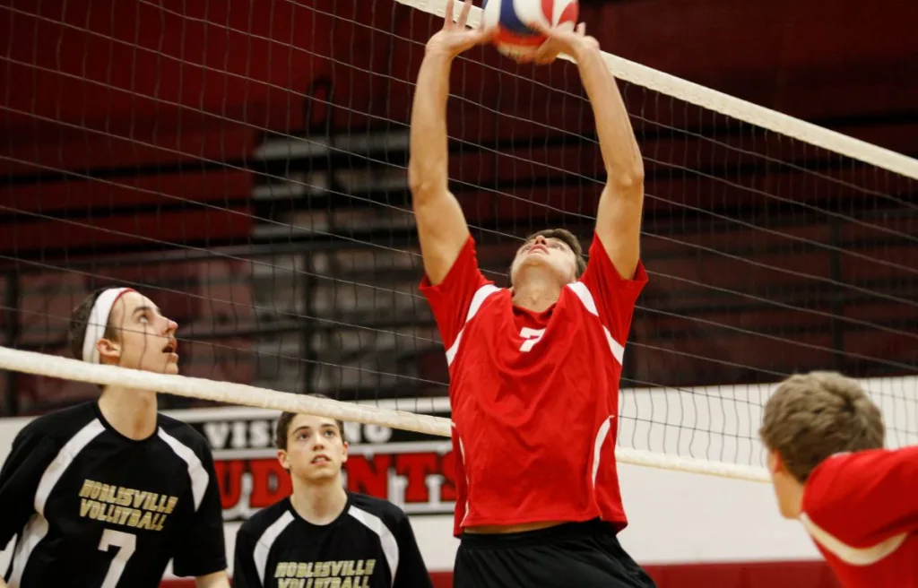A volleyball player trying to tip a ball