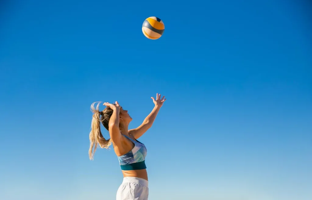 A woman trying to hit the volleyball harder